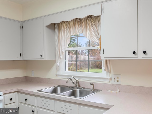 kitchen featuring white cabinetry and sink