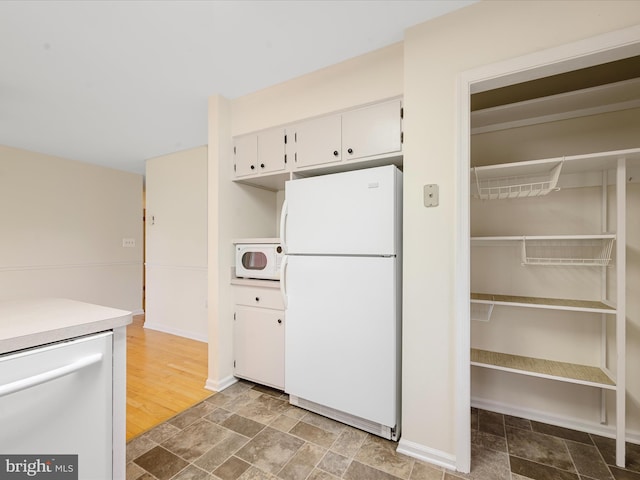 kitchen with white appliances and white cabinets