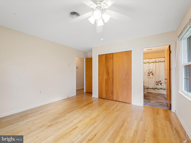 unfurnished bedroom featuring a closet, connected bathroom, ceiling fan, and light hardwood / wood-style floors