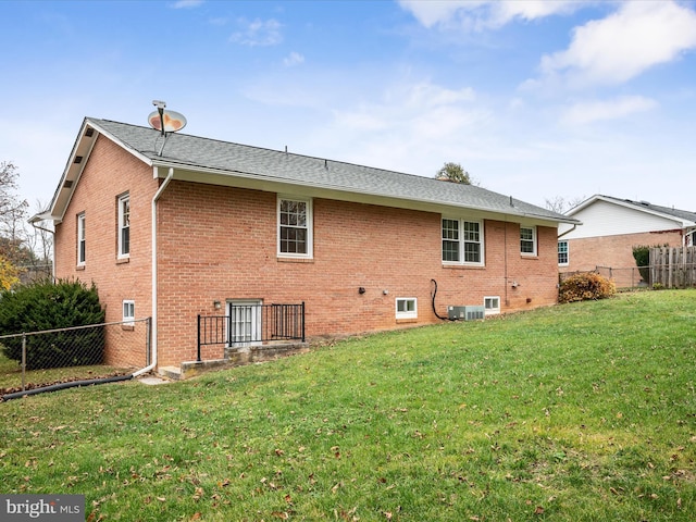 back of property featuring a yard and central air condition unit