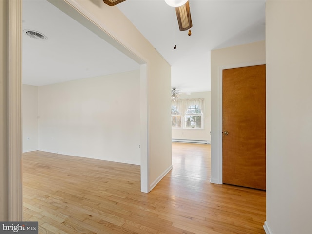 hall with a baseboard radiator and light hardwood / wood-style flooring