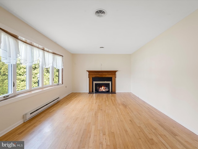 unfurnished living room featuring light hardwood / wood-style floors and baseboard heating