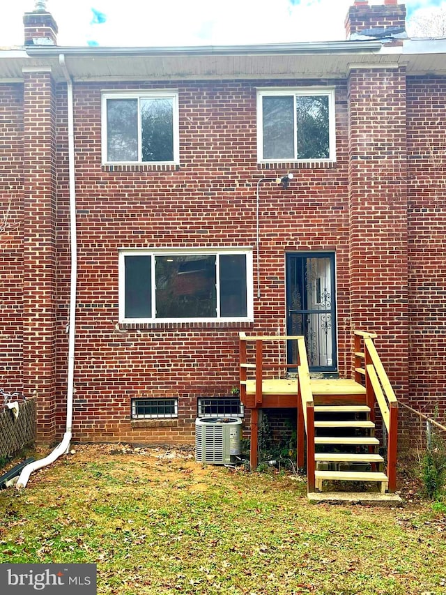 rear view of house with central AC unit and a deck