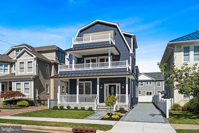 view of front of property featuring a balcony and a front yard