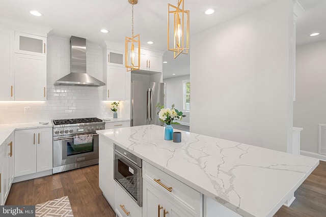 kitchen featuring premium appliances, white cabinetry, wall chimney range hood, and dark wood-type flooring