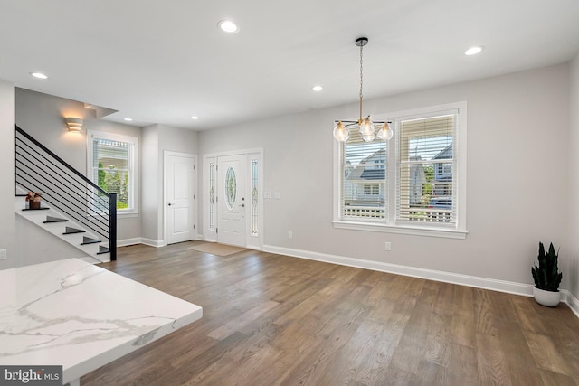 entrance foyer featuring a chandelier and dark hardwood / wood-style flooring