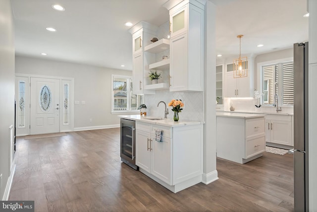 kitchen with backsplash, dark wood-type flooring, white cabinetry, wine cooler, and hanging light fixtures