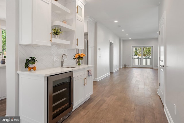 kitchen featuring white cabinets, beverage cooler, and wood-type flooring