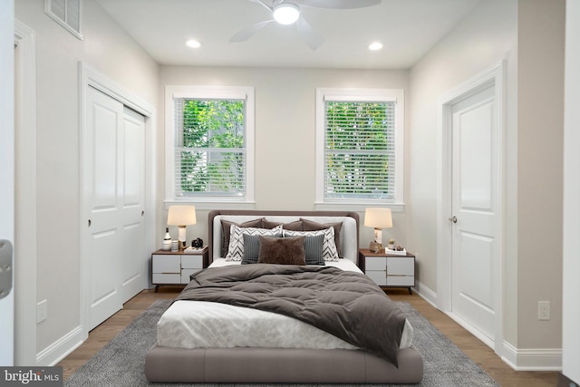 bedroom with hardwood / wood-style flooring, ceiling fan, and a closet