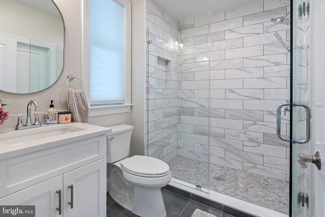 bathroom with tile patterned floors, vanity, toilet, and a shower with shower door