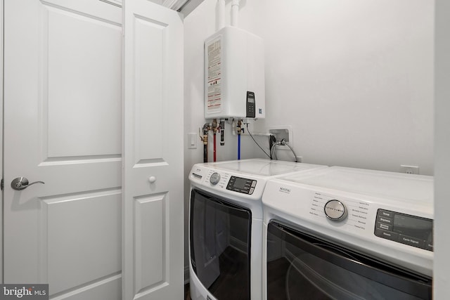 washroom with washer and dryer and water heater