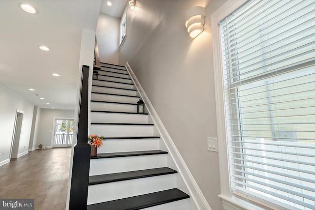 stairs with wood-type flooring and french doors