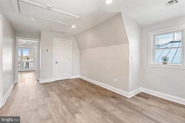 bonus room featuring a healthy amount of sunlight, vaulted ceiling, and light hardwood / wood-style flooring