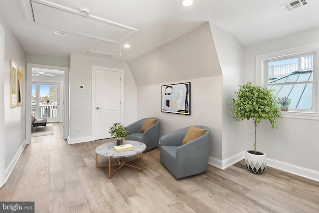 sitting room with light wood-type flooring and lofted ceiling