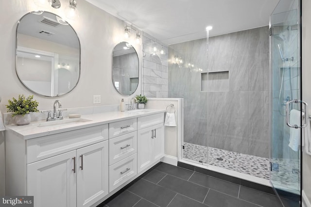 bathroom featuring tile patterned flooring, vanity, and walk in shower