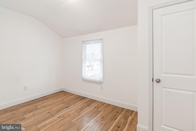 unfurnished room with vaulted ceiling and light hardwood / wood-style flooring