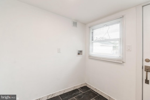 laundry area with dark tile patterned floors and washer hookup