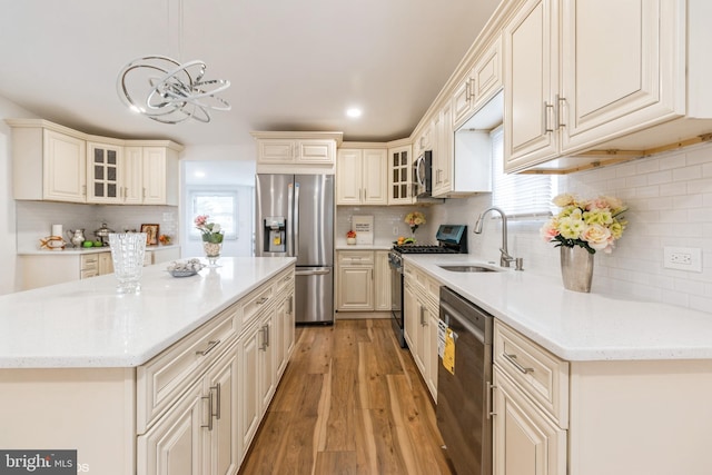 kitchen with a wealth of natural light, stainless steel appliances, hanging light fixtures, and sink