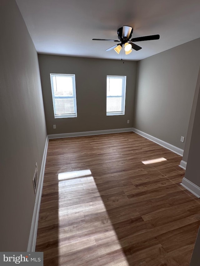 empty room featuring ceiling fan and dark wood-type flooring