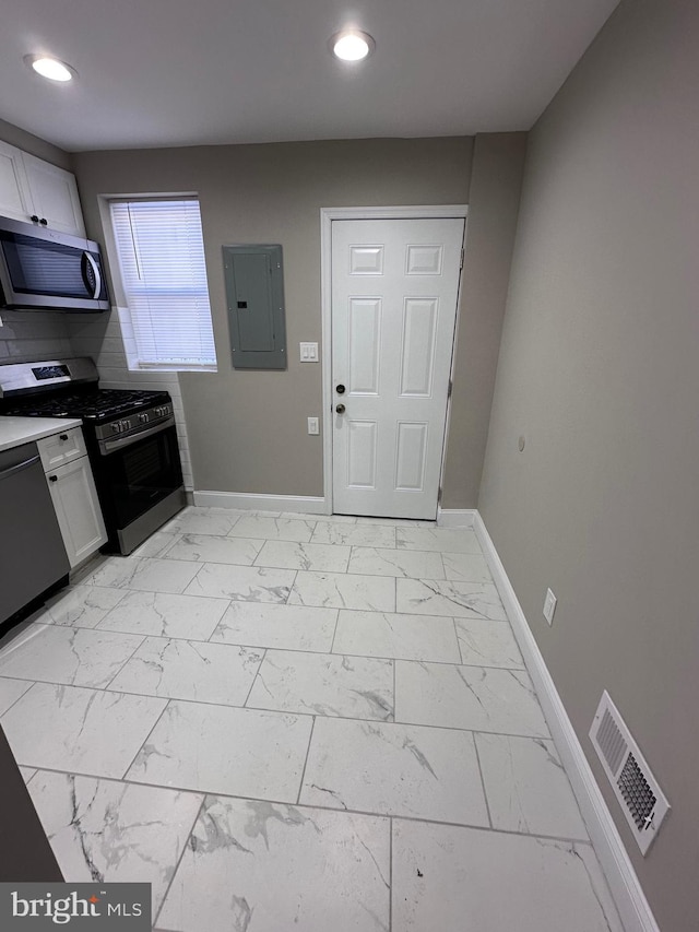 kitchen with white cabinetry, tasteful backsplash, electric panel, and appliances with stainless steel finishes