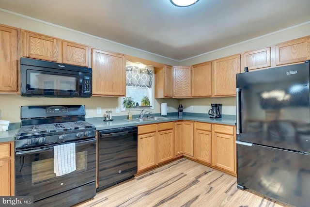 kitchen with light brown cabinets, black appliances, crown molding, sink, and light wood-type flooring