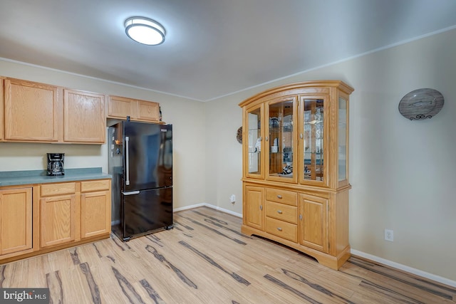 kitchen featuring black refrigerator, light brown cabinetry, and light wood-type flooring