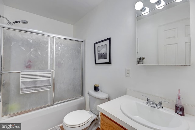 full bathroom with combined bath / shower with glass door, vanity, and toilet