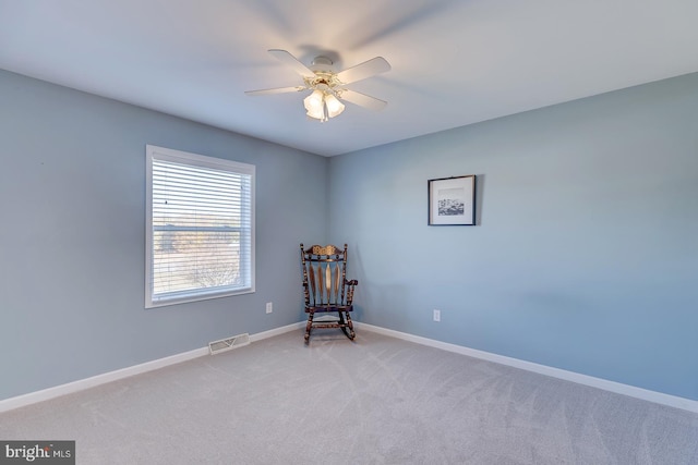 living area with light carpet and ceiling fan