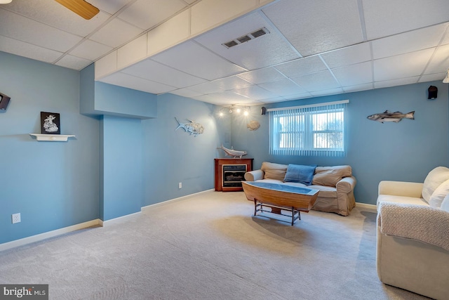 carpeted living room featuring a paneled ceiling and ceiling fan