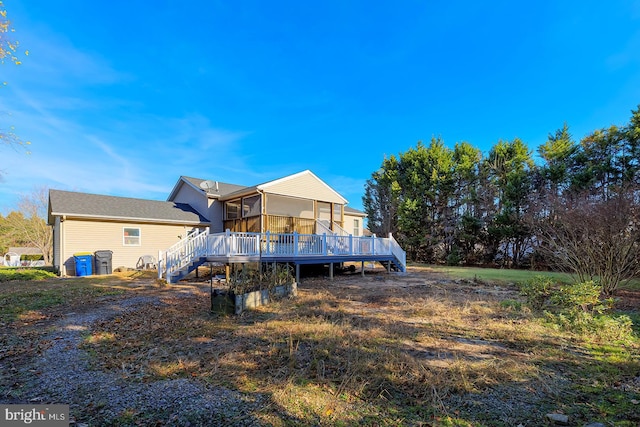 back of property featuring a sunroom and a deck