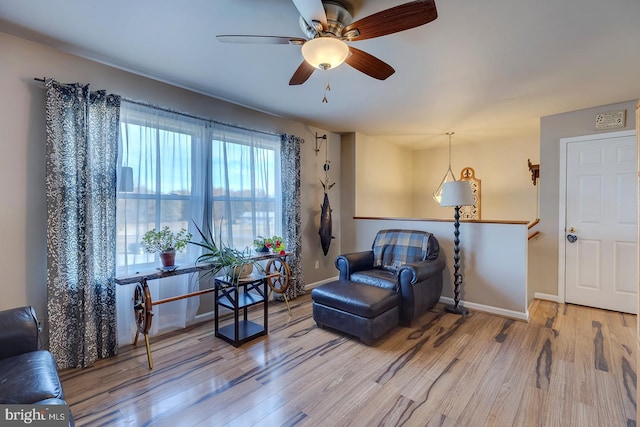 living area featuring ceiling fan and wood-type flooring