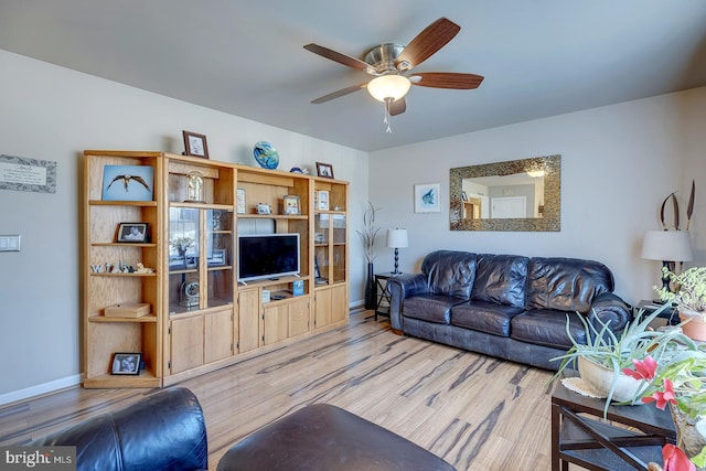 living room with light hardwood / wood-style flooring and ceiling fan