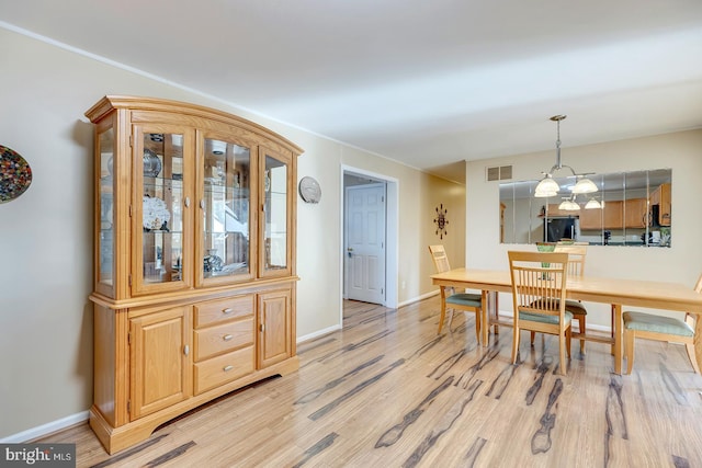 dining area featuring a chandelier and light hardwood / wood-style flooring