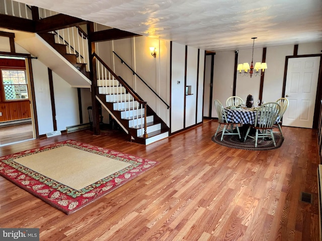 interior space with a notable chandelier, wood-type flooring, and a baseboard radiator