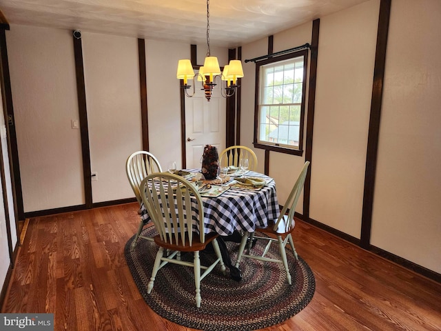 dining area featuring dark hardwood / wood-style floors and an inviting chandelier