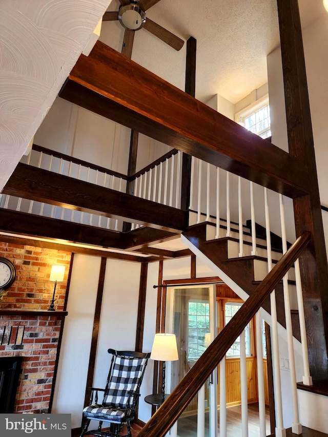 stairs with a textured ceiling and a healthy amount of sunlight