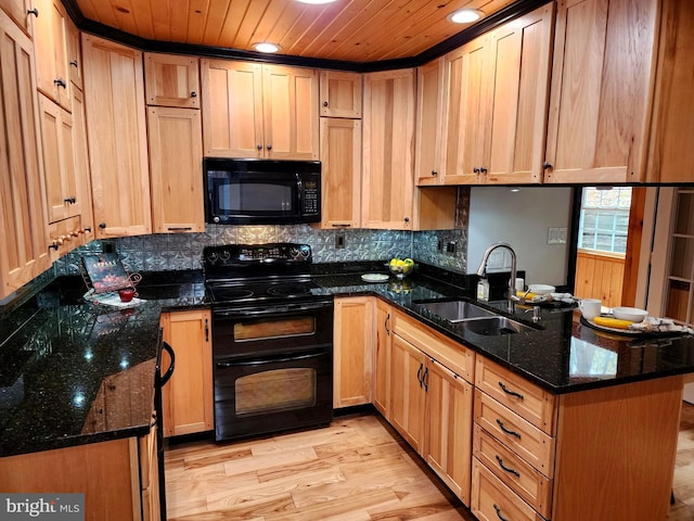 kitchen with dark stone counters, kitchen peninsula, sink, and black appliances