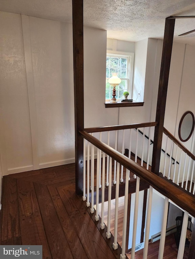 stairs featuring hardwood / wood-style floors and a textured ceiling