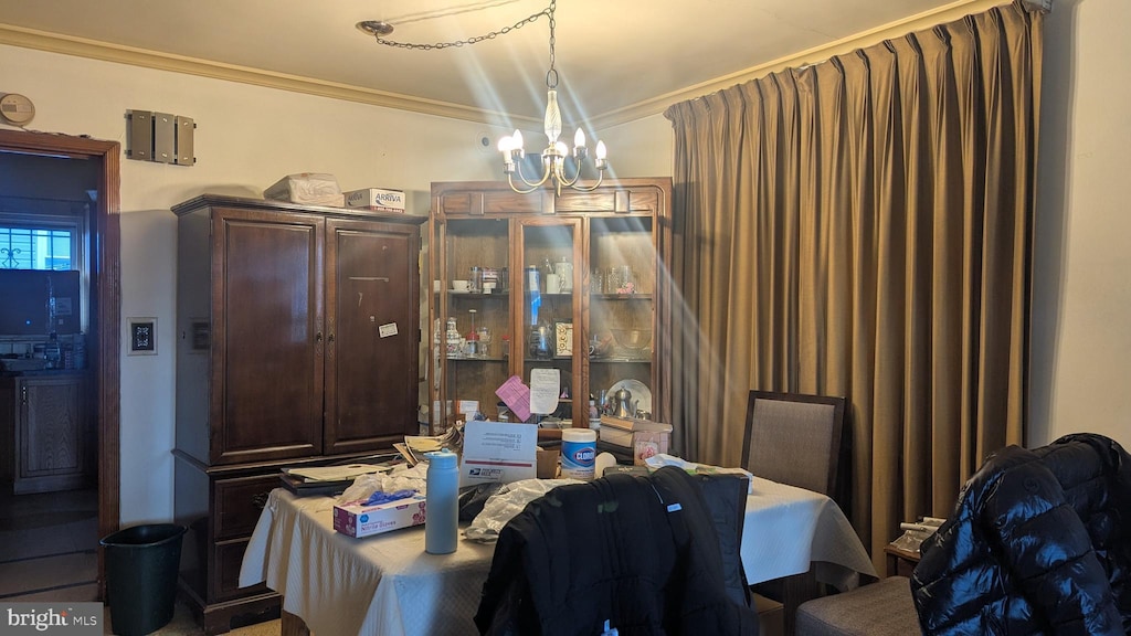 dining area featuring crown molding and an inviting chandelier