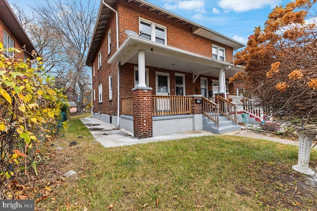 view of front of house with covered porch and a front yard