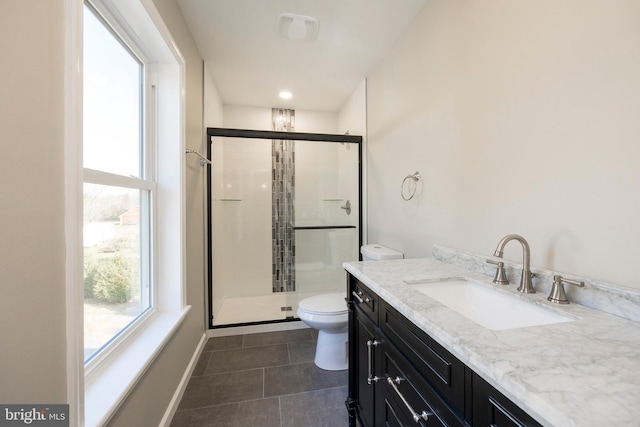 bathroom featuring tile patterned flooring, vanity, toilet, and a shower with door