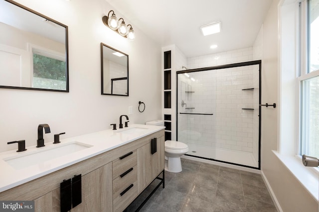 bathroom featuring vanity, toilet, and a shower with door