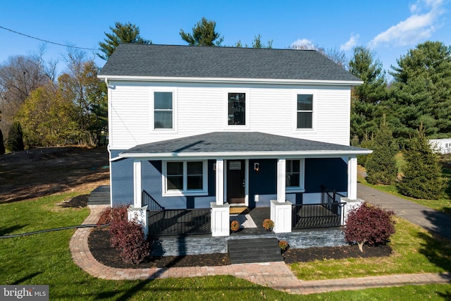 view of front of house featuring covered porch and a front yard