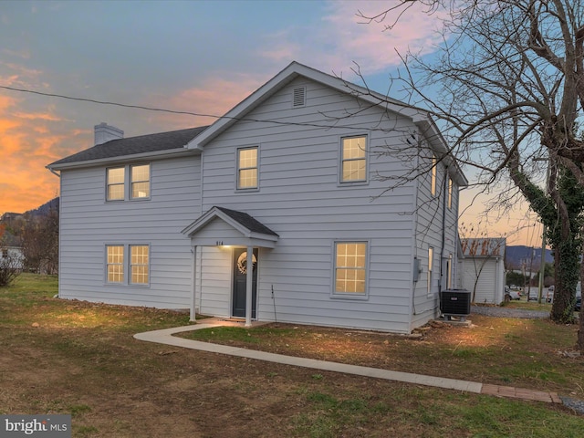 view of front of house with a lawn and cooling unit