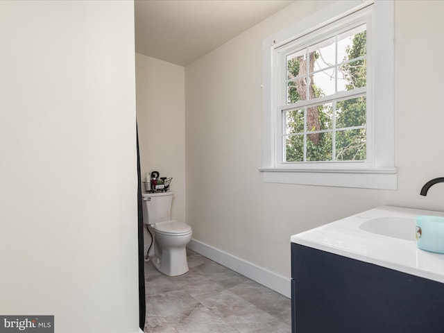 bathroom with vanity, toilet, and a healthy amount of sunlight