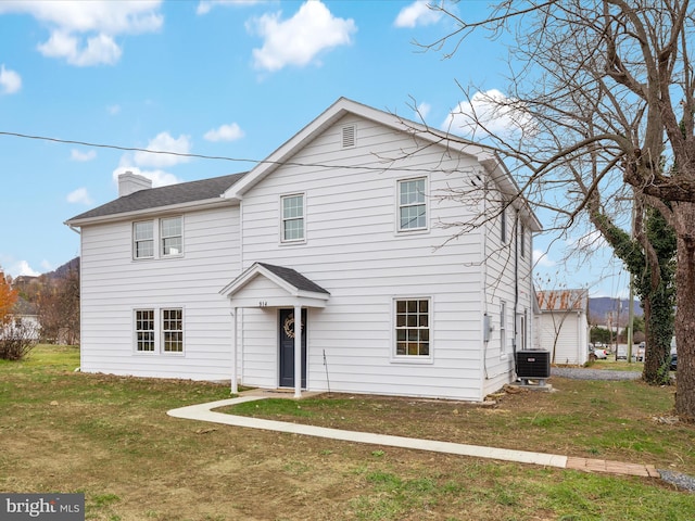 view of front facade with central AC unit and a front yard