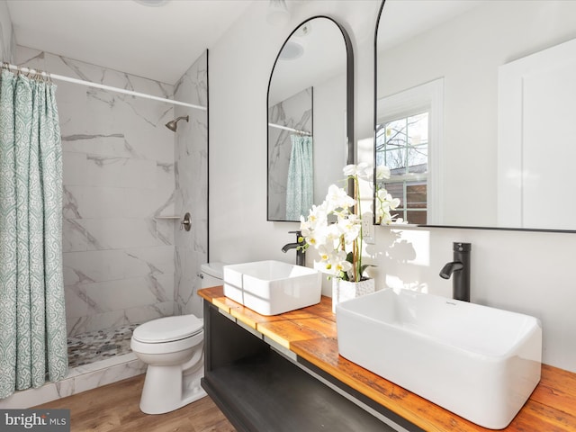 bathroom with a shower with shower curtain, vanity, toilet, and wood-type flooring