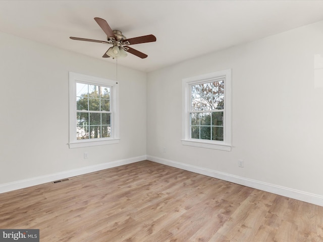 empty room with ceiling fan and light hardwood / wood-style flooring