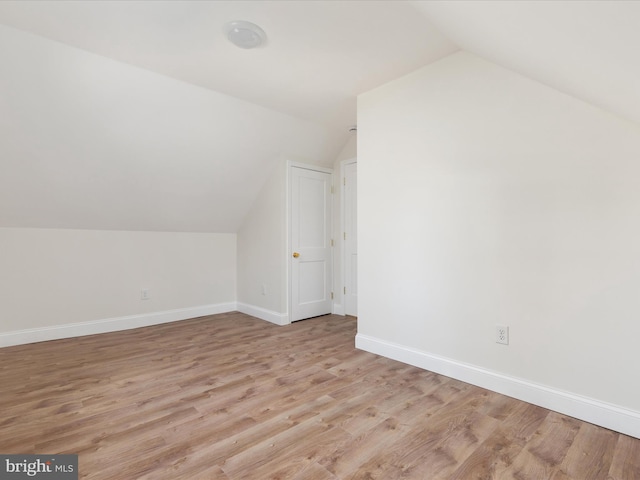 additional living space with lofted ceiling and light wood-type flooring