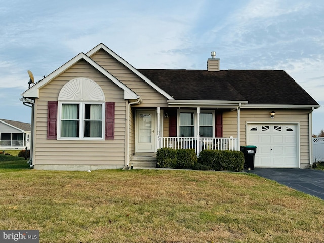 view of front of home featuring covered porch, a garage, and a front lawn